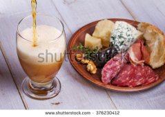 stock-photo-glass-of-beer-cheese-prosciutto-salami-rosemary-nuts-olives-and-bread-376230412